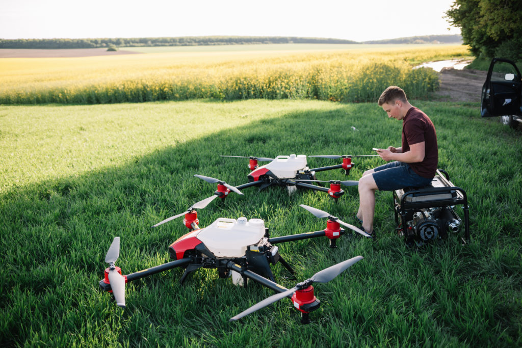 Agriculteur et pilote de drones Drones grands formats avec réservoirs. Prêts pour une pulvérisation de traitements.